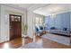 Elegant living room featuring hardwood floors, a decorative chandelier, and a stylish blue accent wall at 3286 Sweetleaf Ln, Buford, GA 30519