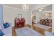 Inviting living room with hardwood floors, a tufted sofa, piano, and view of the elegant dining area at 3286 Sweetleaf Ln, Buford, GA 30519