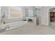 The main bathroom features an elegant soaking tub and a separate glass-enclosed shower, plus walk-in closet access at 3286 Sweetleaf Ln, Buford, GA 30519