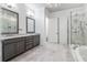 An elegant bathroom showcasing marble tile, double vanities, a glass-enclosed shower and separate soaking tub at 1098 Briar Cove Cir, Atlanta, GA 30329