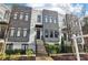 Modern townhome with white brick, gray panels, black framed windows, and black iron fences and stairs at 1098 Briar Cove Cir, Atlanta, GA 30329