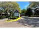 View of community entrance and gatehouse surrounded by lush landscaping and mature trees at 1315 Mcgill Park Ne Ave, Atlanta, GA 30312