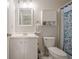 Cozy bathroom with white vanity, toilet, and shower with a blue patterned curtain at 251 Manley Ct, Woodstock, GA 30188