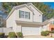 Exterior elevation of a two-story home with white siding, a front-facing garage, and manicured landscaping at 251 Manley Ct, Woodstock, GA 30188