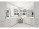 Bright bathroom featuring white cabinetry, marble floors, double vanity, and a glass-enclosed shower at 255 Marjean Way, Alpharetta, GA 30009