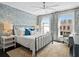 Cozy bedroom featuring a large bed, blue accent wall, and natural light from two windows at 255 Marjean Way, Alpharetta, GA 30009