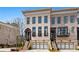 Charming brick townhome featuring arched entryway, second story balcony, and a two car garage at 255 Marjean Way, Alpharetta, GA 30009