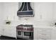 Gourmet kitchen featuring a stainless steel Wolf range and custom vent hood at 255 Marjean Way, Alpharetta, GA 30009