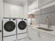 Well-equipped laundry room features modern washer and dryer, granite counters, and ample cabinet space at 255 Marjean Way, Alpharetta, GA 30009