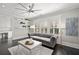 Bright living room with a tufted sofa, decorative shelves, and large windows offering natural light at 255 Marjean Way, Alpharetta, GA 30009