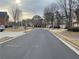 Street view of well-maintained homes, landscaped yards, and a freshly paved road at 4962 Weathervane Dr, Alpharetta, GA 30022