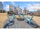 Inviting backyard with Adirondack chairs around firepit with a white house in the background at 239 Sumac Trl, Woodstock, GA 30188