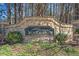 Stone sign for the Woodlands community with manicured greenery at 239 Sumac Trl, Woodstock, GA 30188