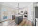 Beautiful kitchen features white cabinets, stainless appliances, gray island with countertop, and a door leading to the deck at 239 Sumac Trl, Woodstock, GA 30188