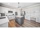 Bright kitchen boasts white cabinets, stainless appliances, subway tile backsplash, and an island with a light gray base at 239 Sumac Trl, Woodstock, GA 30188