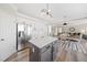 Modern kitchen features white cabinets, stainless steel appliances, an island with a countertop, and views into the dining room at 239 Sumac Trl, Woodstock, GA 30188