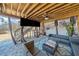 Under-deck patio featuring a large tv, stone floor, comfortable seating and overhead fan at 239 Sumac Trl, Woodstock, GA 30188