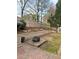 Brick-paved backyard featuring a fire pit area, tiered garden beds, and a wooden privacy fence at 60 Saddle Tree Way, Sugar Hill, GA 30518