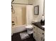 Functional bathroom with a shower and tub combo, white cabinets, dark counter, and dark wood floors at 60 Saddle Tree Way, Sugar Hill, GA 30518