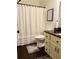 Cozy bathroom with dark wood-look floors, white vanity and ruffled white shower curtain at 60 Saddle Tree Way, Sugar Hill, GA 30518