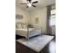 Bright bedroom with light grey walls, wood floors, ceiling fan, a large window, and neutral decor at 60 Saddle Tree Way, Sugar Hill, GA 30518