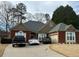 Charming one-story brick home featuring manicured landscaping, a gray roof, and a two-car garage at 60 Saddle Tree Way, Sugar Hill, GA 30518