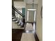 Spacious foyer featuring staircase with iron railing, chandelier, and natural light through front door at 60 Saddle Tree Way, Sugar Hill, GA 30518