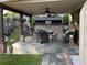 Inviting covered outdoor patio with stone flooring, an outdoor kitchen, and comfortable seating area at 60 Saddle Tree Way, Sugar Hill, GA 30518