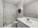 Well-lit bathroom featuring a white single sink vanity and a shower with patterned shower curtain at 840 Cline Petty Way Way, Lawrenceville, GA 30043