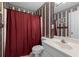 Bathroom with a classic design, featuring striped wallpaper and a shower curtain at 840 Cline Petty Way Way, Lawrenceville, GA 30043