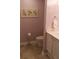 Light pink bathroom with a white vanity, floral art, decorative towel ring and luxury vinyl tile flooring at 1932 Variations Ne Dr, Atlanta, GA 30329