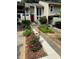 Two-story townhome with a red front door and freshly landscaped flower beds, offering curb appeal at 1932 Variations Ne Dr, Atlanta, GA 30329