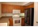 Galley kitchen features white appliances, granite countertops, and oak cabinetry at 1932 Variations Ne Dr, Atlanta, GA 30329