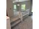 Carpeted living room with stairs and white bannister, with gray wall and white trim, and a bright sunny window at 1932 Variations Ne Dr, Atlanta, GA 30329