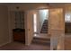 Carpeted living room showcasing the staircase and dry bar with glass shelves and cabinet at 1932 Variations Ne Dr, Atlanta, GA 30329