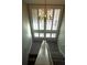 Staircase lit by an elegant chandelier and large window with white shutters allowing plenty of natural light at 1932 Variations Ne Dr, Atlanta, GA 30329