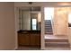 Cozy wet bar features dark granite counters, wood cabinets, a mirror backsplash and floating shelves at 1932 Variations Ne Dr, Atlanta, GA 30329