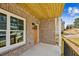 Covered brick front porch with wood ceiling, black railing, and entry door at 3128 Stonegate Sw Dr, Atlanta, GA 30331