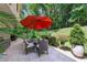 Outdoor patio featuring a dining table with seating, lush plants, and a large umbrella at 1165 E Beechwood Nw Dr, Atlanta, GA 30327
