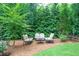 Backyard seating area surrounded by lush greenery, providing a private and tranquil outdoor space at 1165 E Beechwood Nw Dr, Atlanta, GA 30327