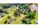 Aerial view shows a home with spacious yard near a lake in a neighborhood with mature trees at 175 Heritage Farm Ln, Fayetteville, GA 30215