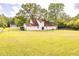 A large and well-maintained backyard features a level lawn and a distant view of the home's rear at 175 Heritage Farm Ln, Fayetteville, GA 30215