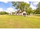 View of a large backyard and fenced-in area with an open garage and mature trees, showcasing ample outdoor space at 175 Heritage Farm Ln, Fayetteville, GA 30215