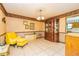 Cozy dining room featuring tile floors, a charming china cabinet, and bright yellow sitting chair at 175 Heritage Farm Ln, Fayetteville, GA 30215