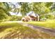 Charming home featuring a lovely front yard, long driveway, attached garage, and inviting front porch at 175 Heritage Farm Ln, Fayetteville, GA 30215