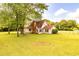 Charming one-story home with a brick chimney and a large front yard filled with mature shade trees at 175 Heritage Farm Ln, Fayetteville, GA 30215