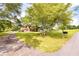 A single-Gathering home's spacious front yard with mature trees, with a paved driveway leading up to the house at 175 Heritage Farm Ln, Fayetteville, GA 30215