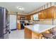Efficient kitchen with wood cabinets, eat-in bar area, updated appliances, and a bright window at 175 Heritage Farm Ln, Fayetteville, GA 30215