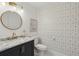Stylish powder room features a geometric accent wall, modern vanity, and round mirror adding a touch of elegance at 63 Fulton Se St, Atlanta, GA 30312
