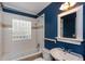 Bright bathroom featuring a tub, a tile window, and stylish fixtures against blue walls at 148 Murray Hill Ne Ave, Atlanta, GA 30317